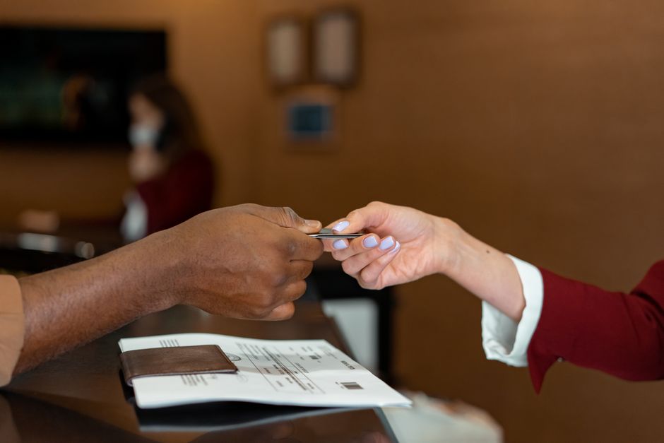 Hotel receptionist receiving a credit card payment from a guest at check-in